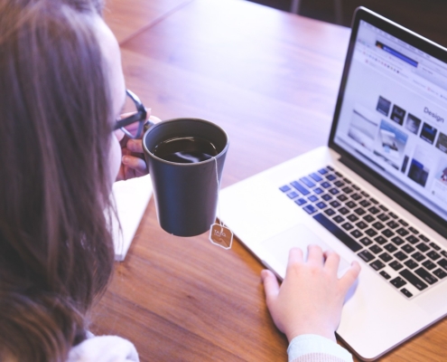 Woman with laptop and cup of coffee - Web designer tools