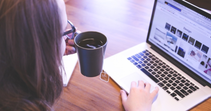 Woman with laptop and cup of coffee - Web designer tools