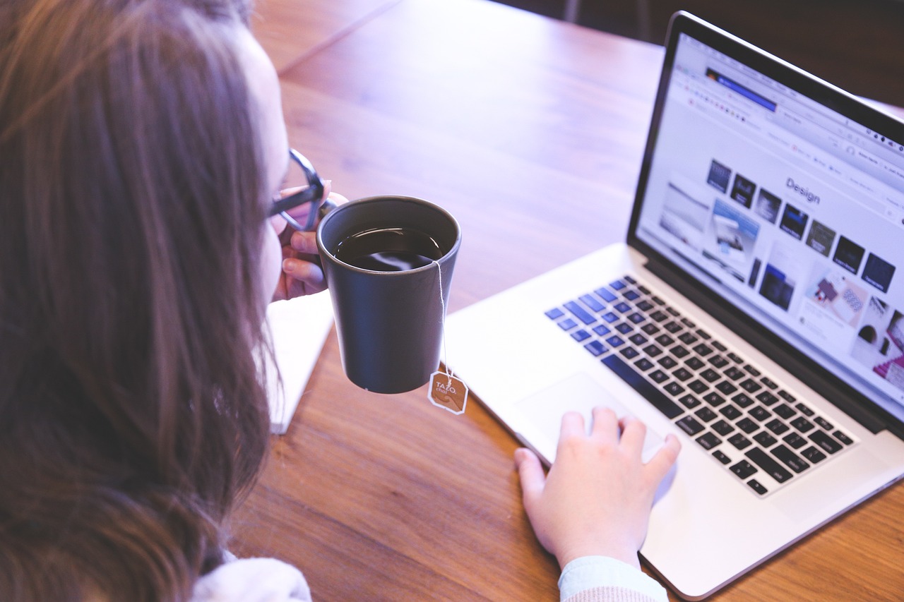 Woman with laptop and cup of coffee - Web designer tools